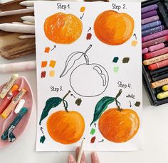 a child's drawing of an orange on paper with markers and crayons next to it