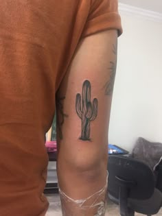 a person with a tattoo on their arm and a cactus in the middle of his arm