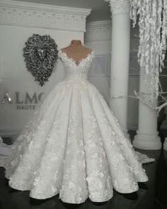 a white wedding dress on display in a room