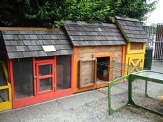 several different colored chicken coops on the sidewalk