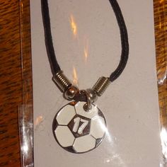 a necklace with a soccer ball and number 17 in the center on a black cord