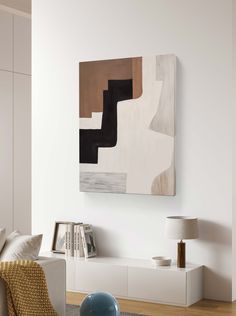 an abstract painting hangs on the wall above a white couch in a modern living room