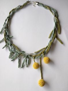 a necklace with yellow beads and green leaves