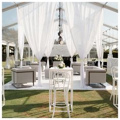 an outdoor wedding venue with white furniture and drapes on the ceiling, set up for a formal function