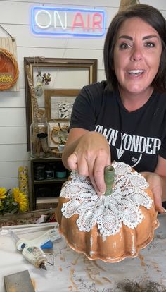 a woman is decorating a cake on a table