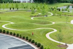 an aerial view of a parking lot with several curved roads and trees in the background