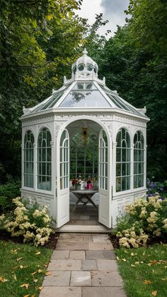 a white gazebo sitting in the middle of a garden