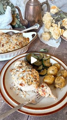 a white plate topped with food next to a bowl of potatoes and cucumbers