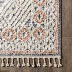 an area rug with tassels on top of it