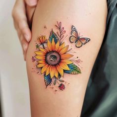 a woman's thigh with a sunflower and butterflies tattoo on her left leg