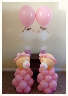 two teddy bears with pink and white balloons