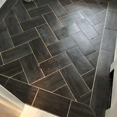 a bathroom with black and white tiles on the floor