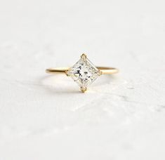 a gold ring with a princess cut diamond