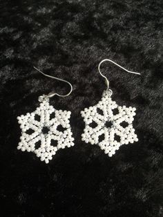 white beaded snowflake earrings on black fur