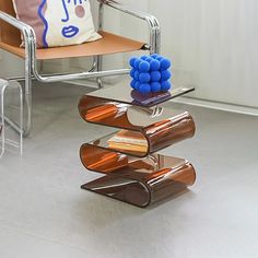 a chair with a pillow on top of it next to a stack of glass objects