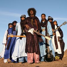 a group of people standing next to each other with guitars in their hands and one person holding a guitar