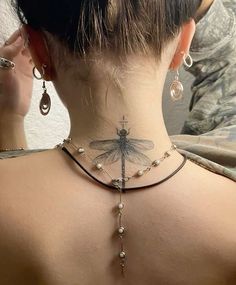 a woman with a dragonfly tattoo on her back