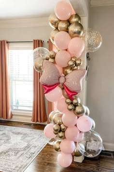 a bunch of balloons that are in the shape of hearts on a table next to a window