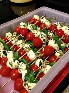 tomatoes and mozzarella on skewers in a plastic container, ready to be served