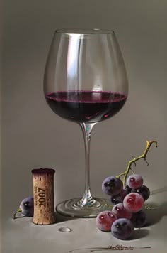 a glass of wine and some grapes on a table