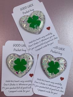 three heart shaped brooches with green shamrock leaves on them, one has a good luck poem