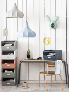 a desk with several different colored lamps hanging from the ceiling