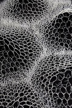 an abstract black and white photograph of some kind of pattern on the surface of a piece of cloth