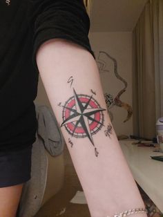 a person with a compass tattoo on their arm