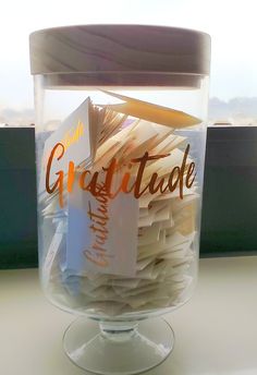 a glass jar filled with books on top of a table