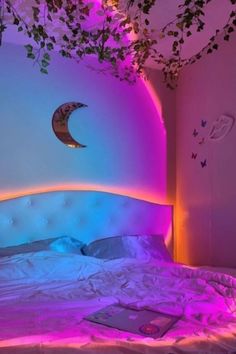 a bed that has some plants growing on the headboard and it is lit up with purple light