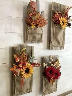 three wall hangings decorated with fall flowers and leaves on white wood planked walls