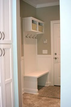 a mud room with a bench and some shelves on the wall, next to a door