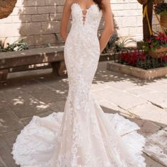 a woman in a white wedding dress standing on the ground with her back to the camera