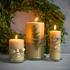 three lit candles sitting next to each other