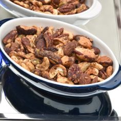 two bowls filled with nuts on top of a table