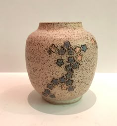 a brown vase sitting on top of a white table