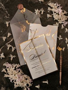 the wedding stationery is laid out on top of the table with flowers and confetti