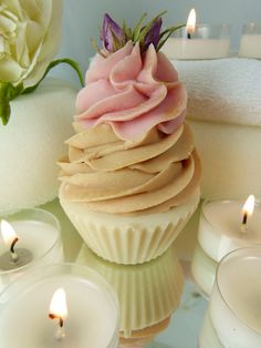 a cupcake sitting on top of a table next to candles