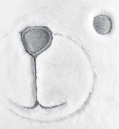 a close up of a white teddy bear's face