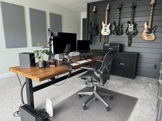 an office with guitars on the wall and desk