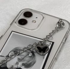 a cell phone case with a chain attached to the back of it and a heart shaped keychain