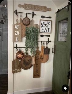 a kitchen wall filled with wooden cutting boards and utensils hanging on the wall