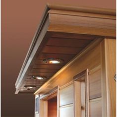 the lights are on above the kitchen cabinets and cupboards in this room with wood paneling