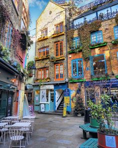 an alleyway with tables and chairs in front of buildings