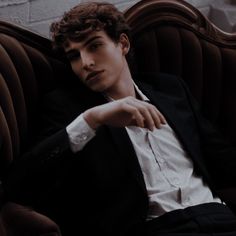 a young man sitting on top of a purple couch