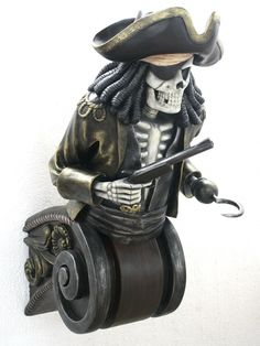 a figurine of a skeleton riding a bike with a pirate hat and eye patch