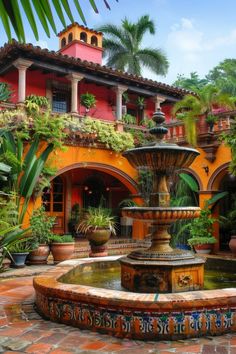 a fountain in the middle of a courtyard surrounded by potted plants