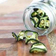 an open jar filled with cut up zucchini on top of a wooden table