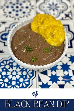 black bean dip in a white bowl on a blue and white tile floor with the title above it