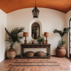 an entryway with potted plants and a mirror